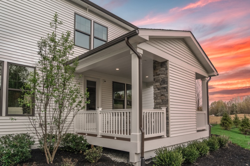 View of Porch in the Sunset with Brown Window Trim and Gutters